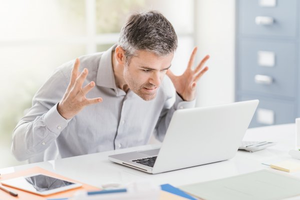 Advanced System Optimizer software system optimizer utility software overview benefits angry man frustrated annoyed in front of white laptop in office